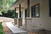 Squared sandstone pillars with hand-chiselled coping stone. Stone paved entry and retaining wall